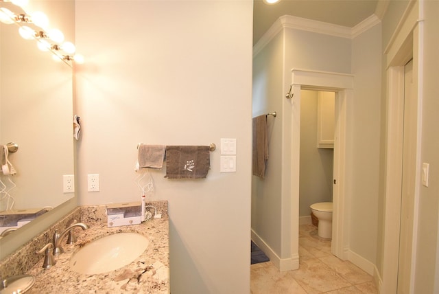 bathroom with tile patterned flooring, ornamental molding, vanity, and toilet