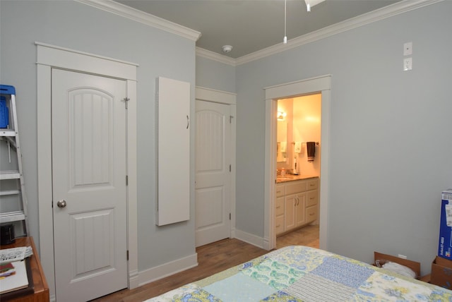 bedroom featuring crown molding, ensuite bath, and light hardwood / wood-style floors