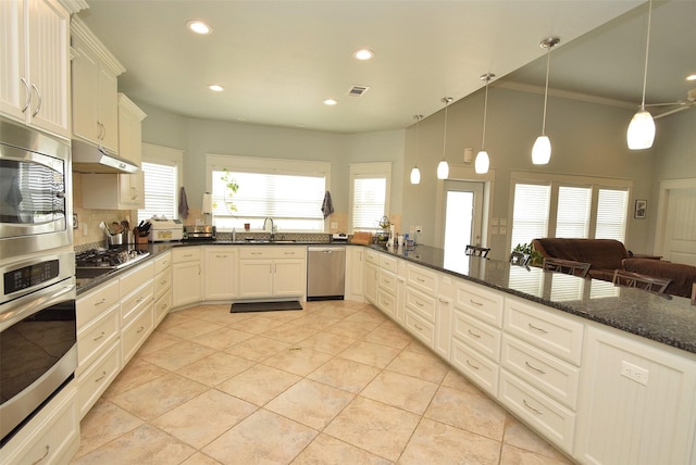 kitchen with sink, white cabinetry, decorative light fixtures, appliances with stainless steel finishes, and dark stone counters