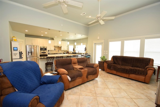 tiled living room with a high ceiling, ornamental molding, and ceiling fan