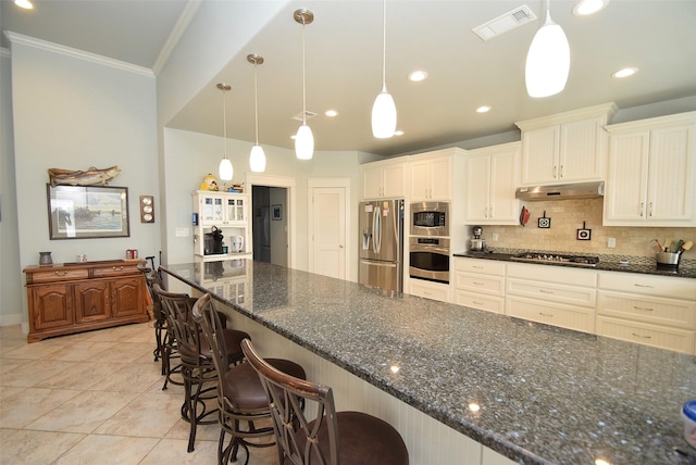 kitchen with a kitchen bar, decorative light fixtures, dark stone counters, and appliances with stainless steel finishes