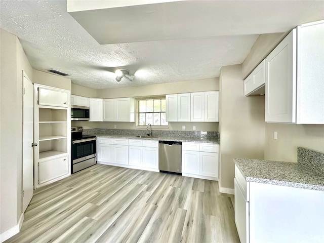 kitchen featuring white cabinets, stainless steel appliances, light hardwood / wood-style flooring, and sink