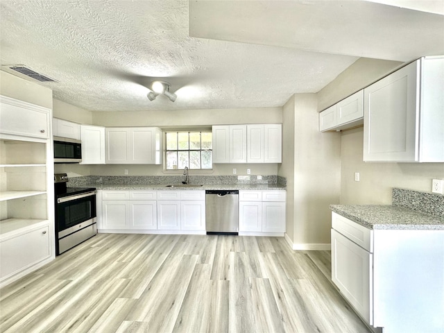 kitchen with sink, light hardwood / wood-style flooring, stainless steel appliances, and white cabinets