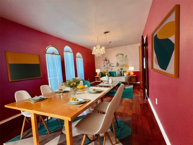 dining area featuring an inviting chandelier and dark hardwood / wood-style flooring