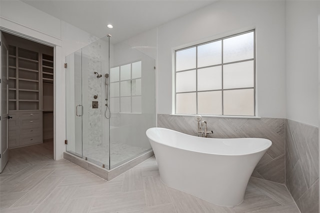 bathroom with independent shower and bath and tile walls