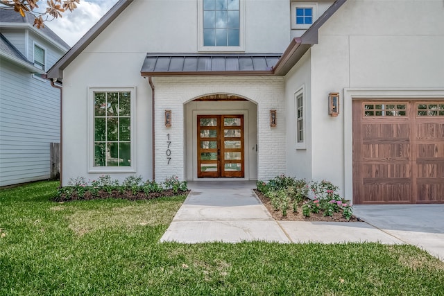 doorway to property featuring a lawn and a garage