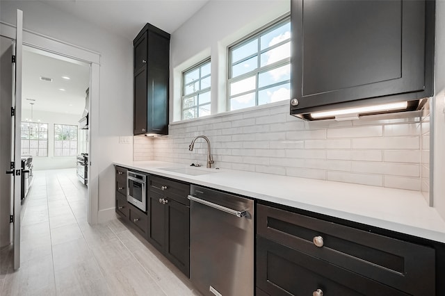 kitchen with backsplash, appliances with stainless steel finishes, light tile patterned floors, and sink