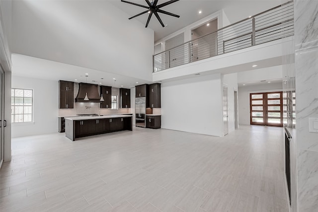 living room featuring a healthy amount of sunlight, a towering ceiling, and ceiling fan