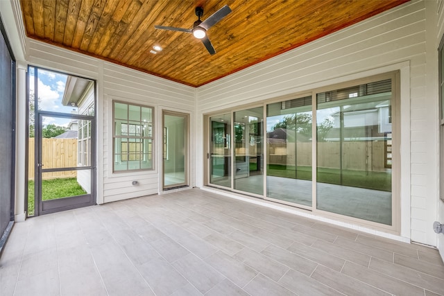 unfurnished sunroom featuring wooden ceiling and ceiling fan