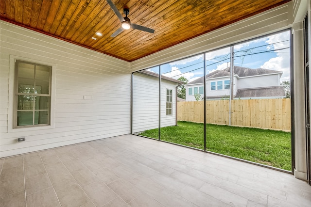 unfurnished sunroom with wood ceiling and ceiling fan