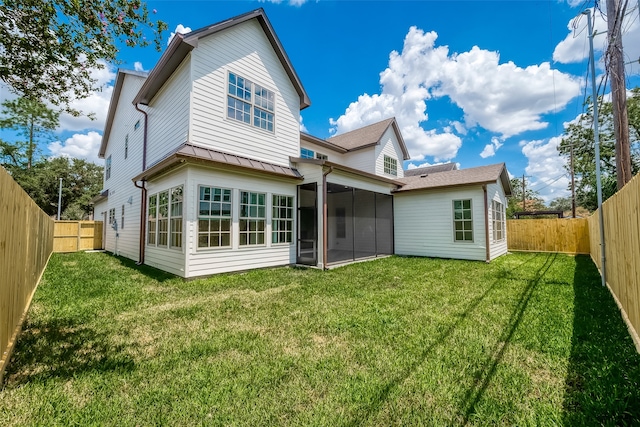 back of property with a sunroom and a yard