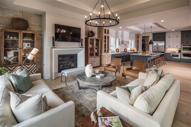 living room featuring a notable chandelier, hardwood / wood-style floors, and a tray ceiling