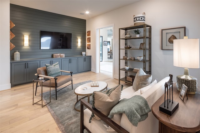 living room with wood walls and light wood-type flooring