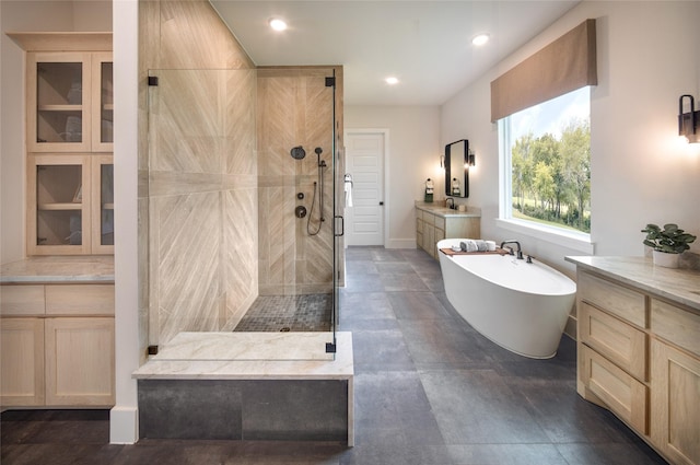 full bathroom with a stall shower, a freestanding tub, vanity, and recessed lighting