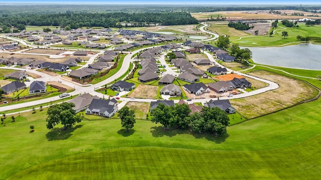 drone / aerial view featuring a residential view, view of golf course, and a water view