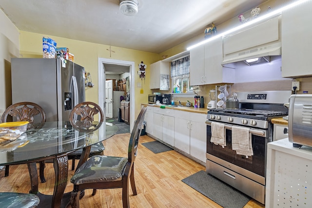 kitchen with light hardwood / wood-style flooring, premium range hood, white cabinets, and stainless steel appliances