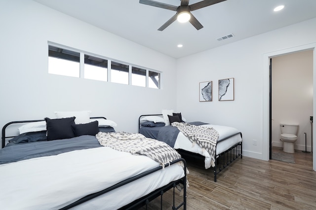 bedroom with wood-type flooring, ensuite bathroom, and ceiling fan