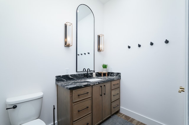 bathroom featuring vanity, toilet, and hardwood / wood-style floors