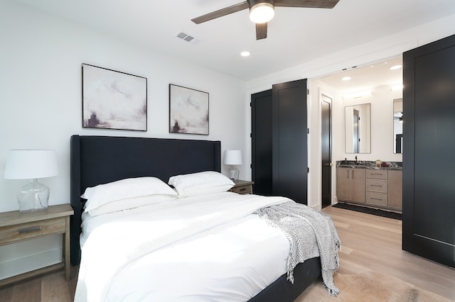 bedroom featuring sink, ceiling fan, and light wood-type flooring