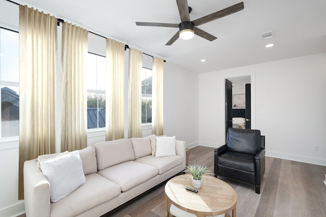 living room with dark wood-type flooring and ceiling fan