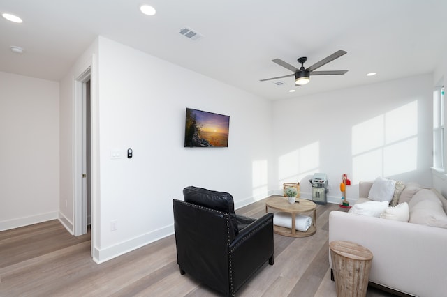 living room featuring light hardwood / wood-style flooring and ceiling fan