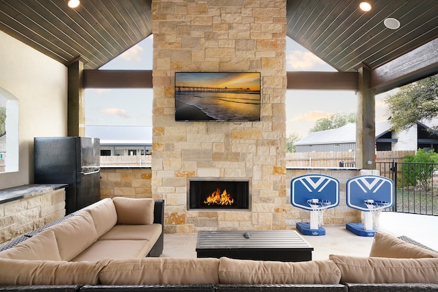 view of patio / terrace with an outdoor living space with a fireplace and exterior kitchen