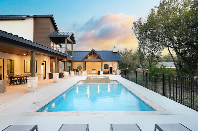 pool at dusk with a patio area