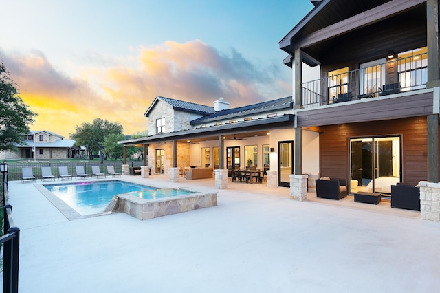 pool at dusk featuring a patio