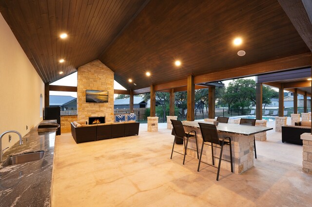 view of patio / terrace with an outdoor wet bar and a stone fireplace