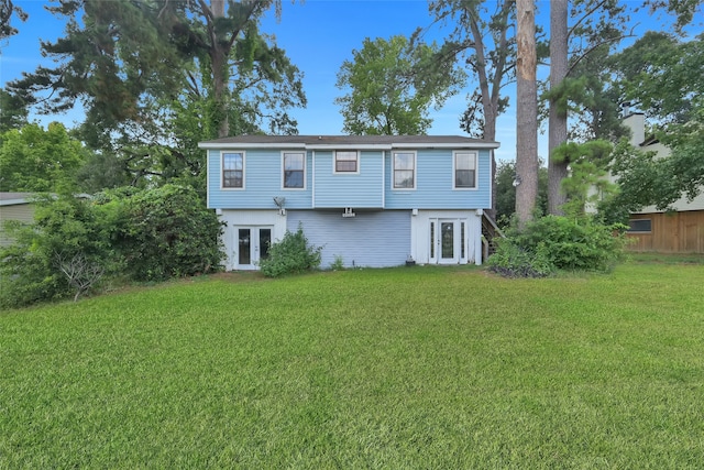 back of house featuring french doors and a lawn