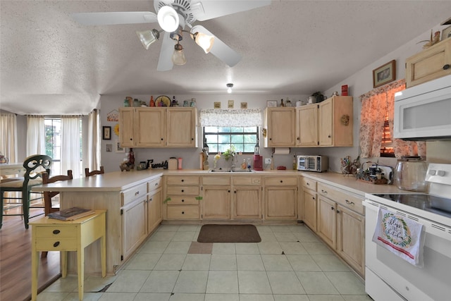 kitchen featuring white appliances, kitchen peninsula, sink, and light brown cabinets