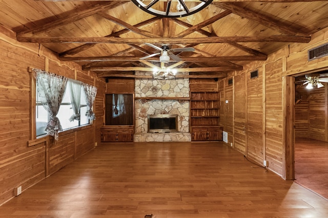 unfurnished living room with wood ceiling, wood-type flooring, ceiling fan, and a stone fireplace