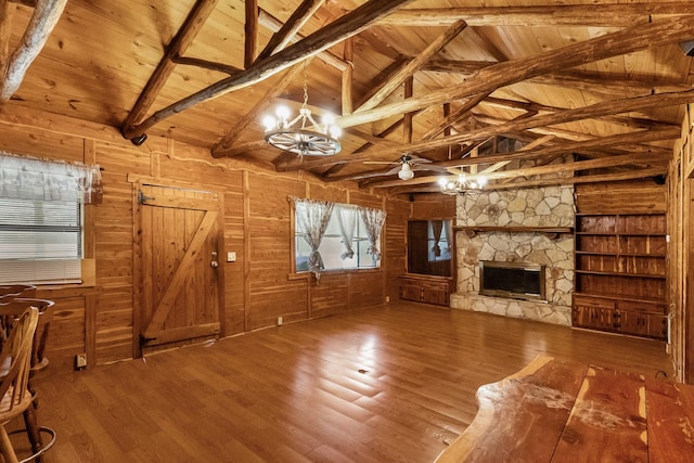 unfurnished living room with wooden walls, wooden ceiling, wood finished floors, vaulted ceiling with beams, and a stone fireplace