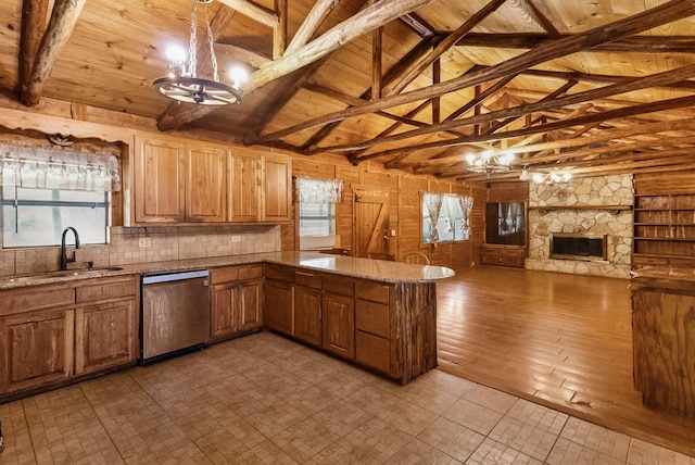 kitchen with dishwasher, wood ceiling, a notable chandelier, a stone fireplace, and a sink