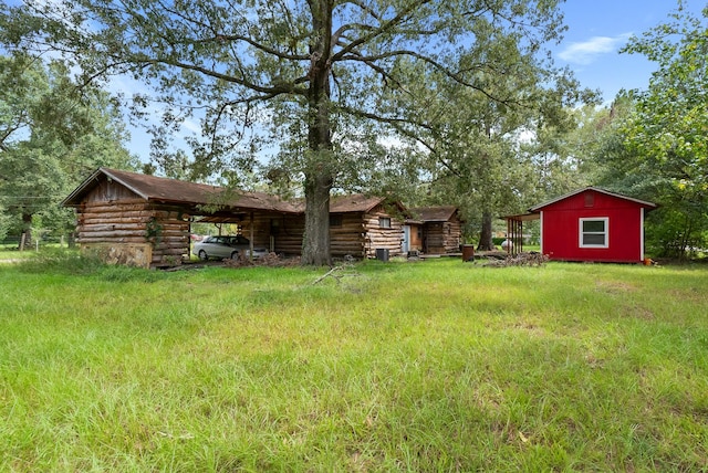 view of yard with a storage unit, a carport, and an outdoor structure