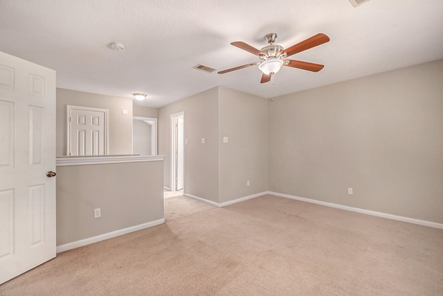 carpeted spare room featuring ceiling fan