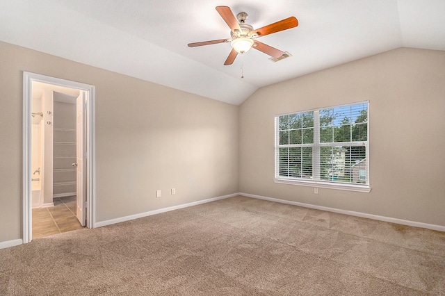 carpeted empty room featuring ceiling fan and vaulted ceiling