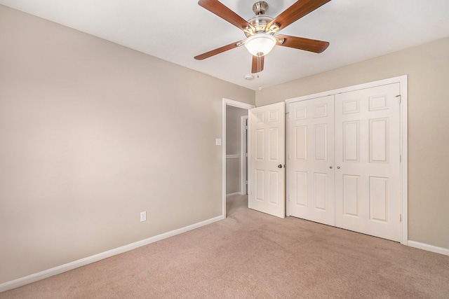 unfurnished bedroom with light carpet, ceiling fan, and a closet