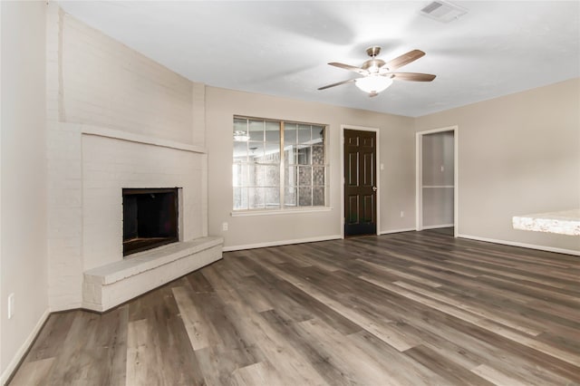 unfurnished living room featuring ceiling fan, a fireplace, and dark hardwood / wood-style flooring