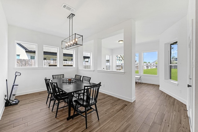 dining space featuring an inviting chandelier and hardwood / wood-style flooring