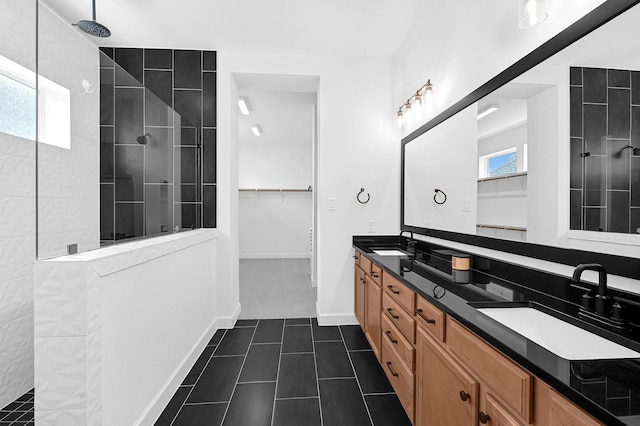 bathroom featuring vanity, a tile shower, and tile patterned floors