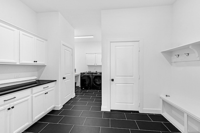 interior space featuring independent washer and dryer and dark tile patterned flooring