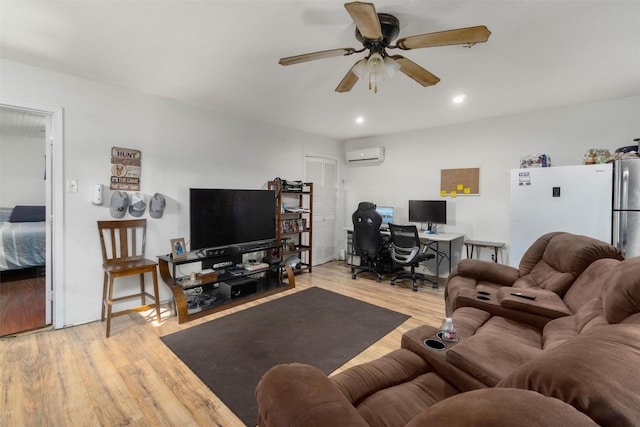 living room with light hardwood / wood-style flooring, a wall unit AC, and ceiling fan