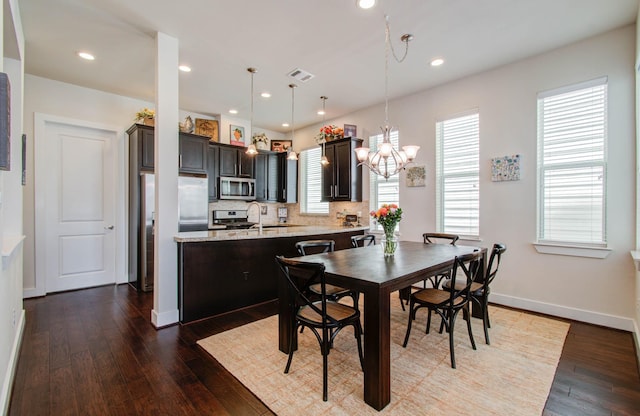 dining space featuring a notable chandelier and dark wood-type flooring