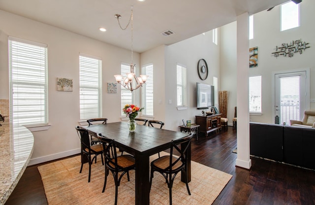 dining room with a healthy amount of sunlight, dark hardwood / wood-style floors, and an inviting chandelier