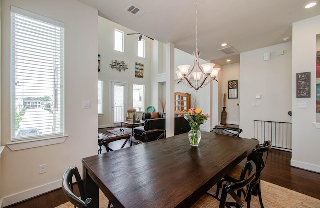 dining area featuring plenty of natural light, an inviting chandelier, and hardwood / wood-style flooring