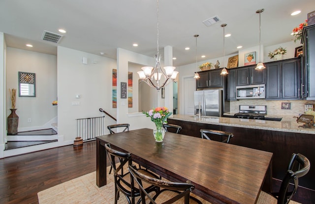 dining room with dark hardwood / wood-style floors and a chandelier