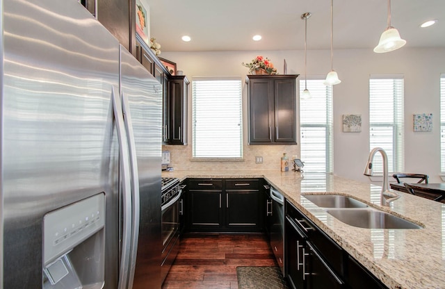 kitchen featuring sink, hanging light fixtures, stainless steel appliances, tasteful backsplash, and dark hardwood / wood-style flooring