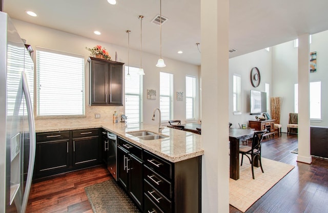 kitchen with dark wood-type flooring, hanging light fixtures, stainless steel appliances, and sink