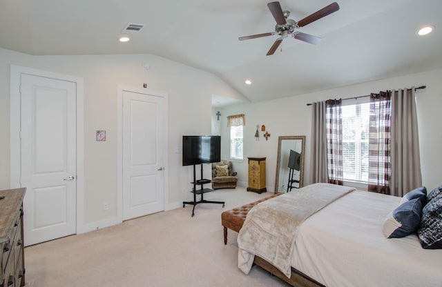 carpeted bedroom with multiple windows, ceiling fan, and vaulted ceiling